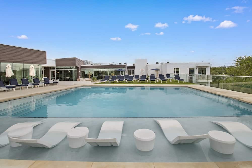 A wooden table in the foreground of a photo showing a community gathering in the background